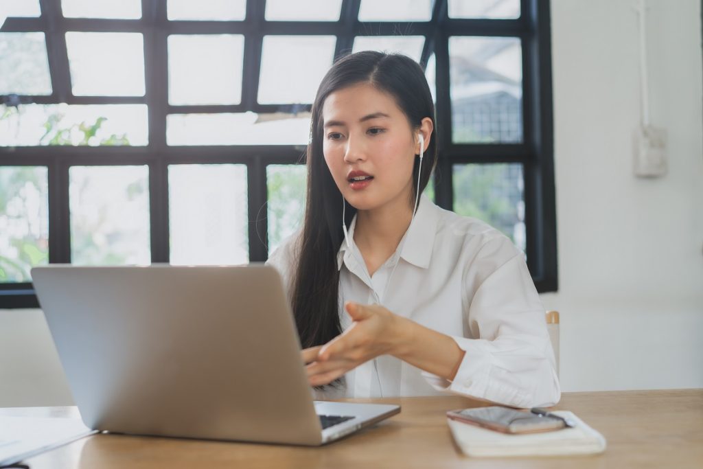 Person in virtual meeting looking at laptop