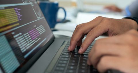 Photo of hands on a laptop coding